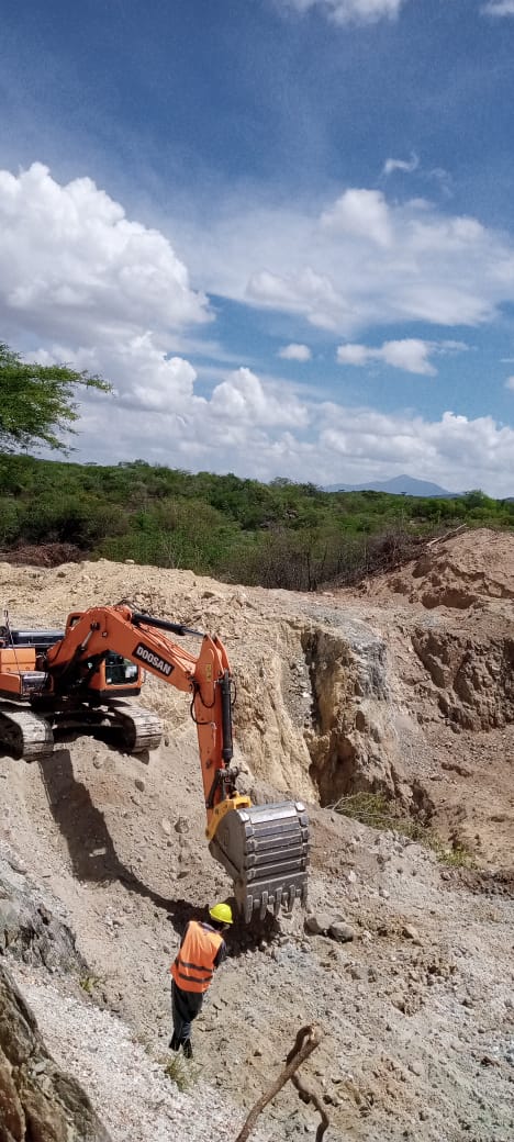 Excavator and field worker inside the mining area