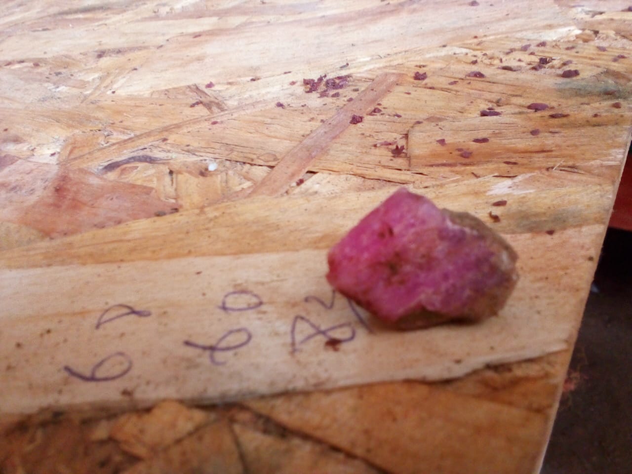 Single rough red stone sample on a work surface
